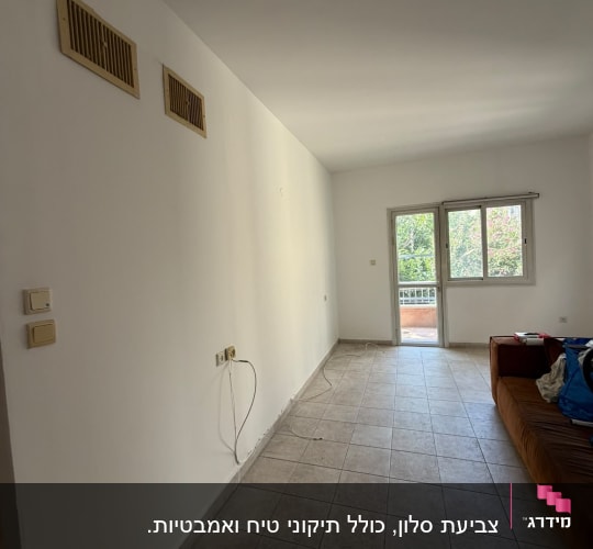 חדר ריק עם קיר לבן ורצפת אריחים